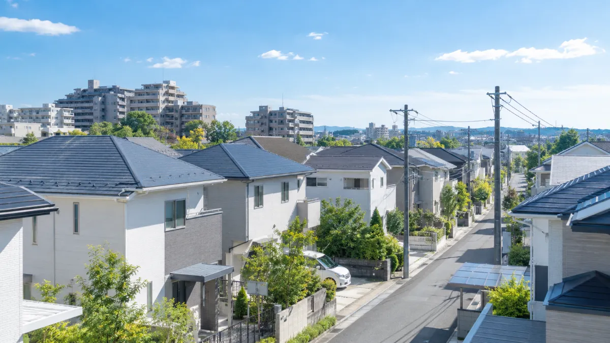 一戸建ての住宅とマンションが並ぶ住宅街を少し高い位置から見た様子